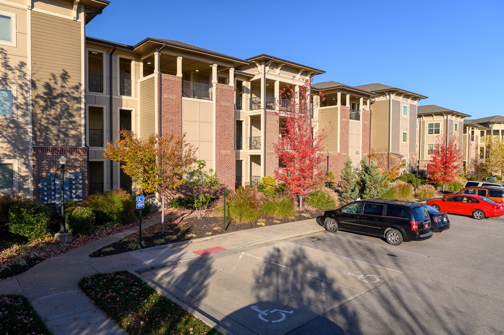 an apartment building with cars parked in a parking lot
