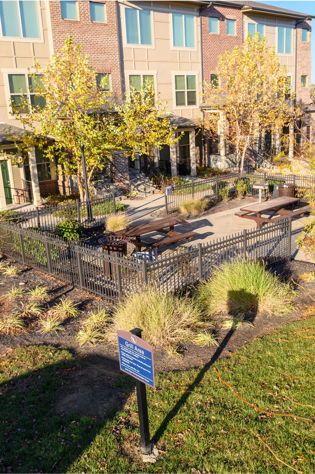 a park with benches and trees in front of a building