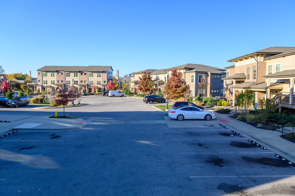 a parking lot with cars in front of apartment buildings
