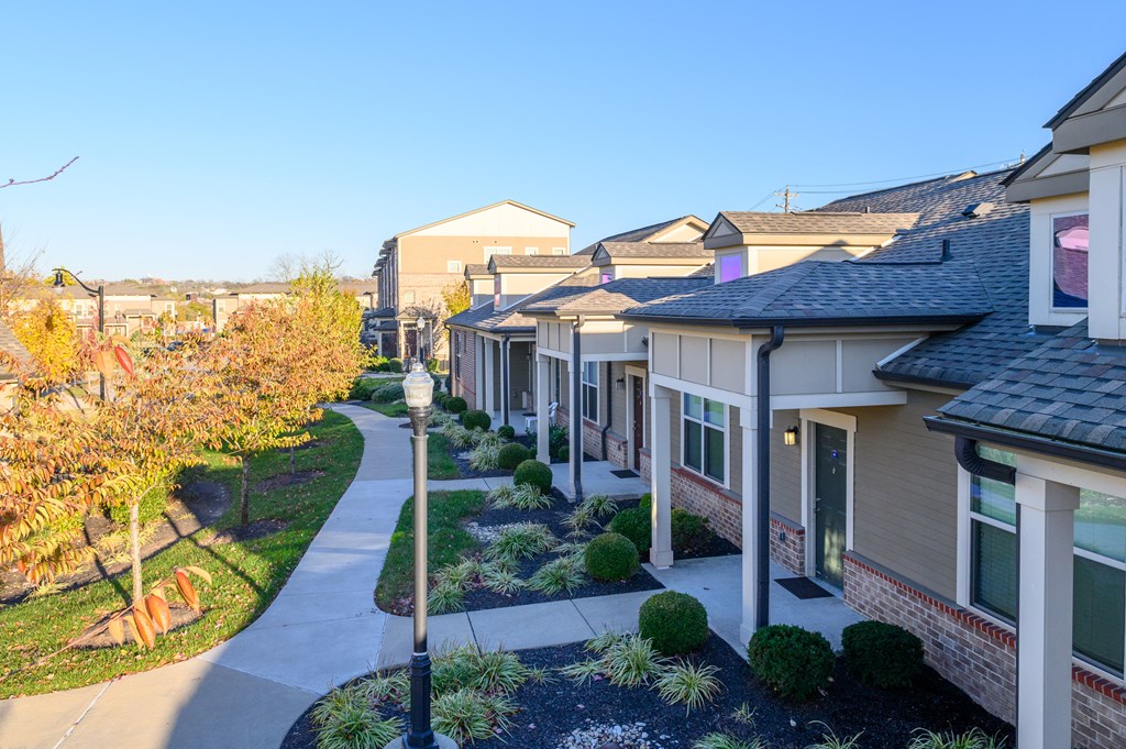 a row of houses with a sidewalk in front of them