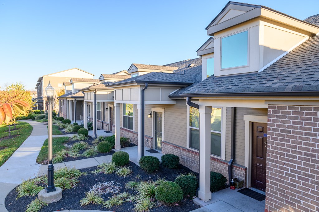 a row of townhomes with a sidewalk in front of them