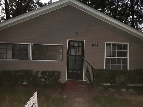 A house with a grey siding and a black door.