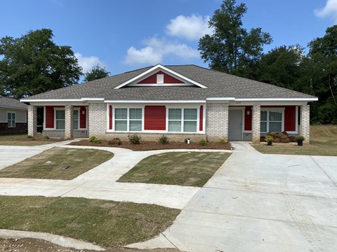 a house with a red door and a lawn