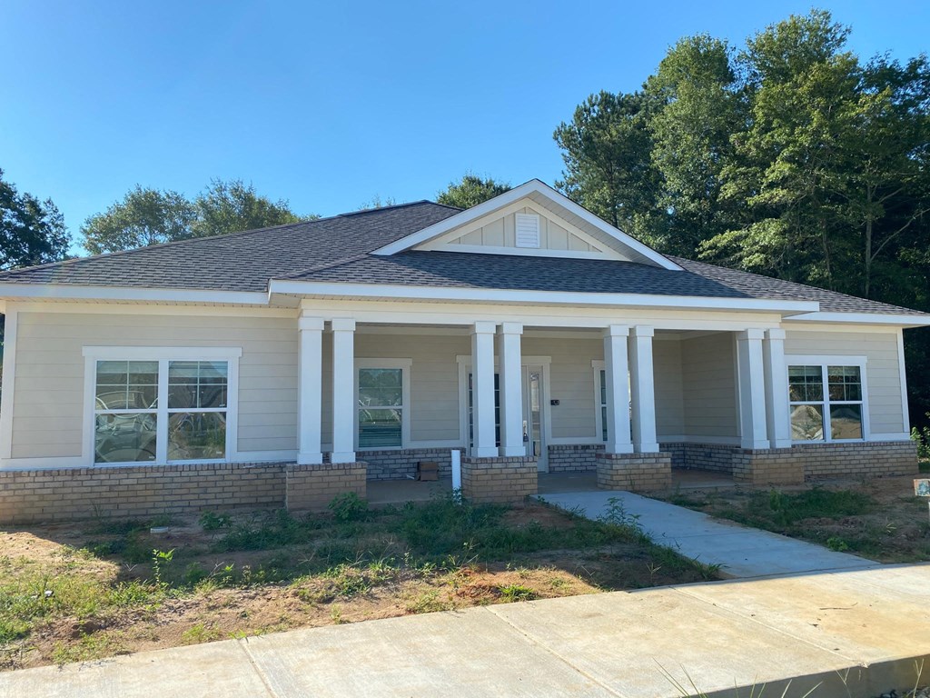 the front of a house with trees in the background