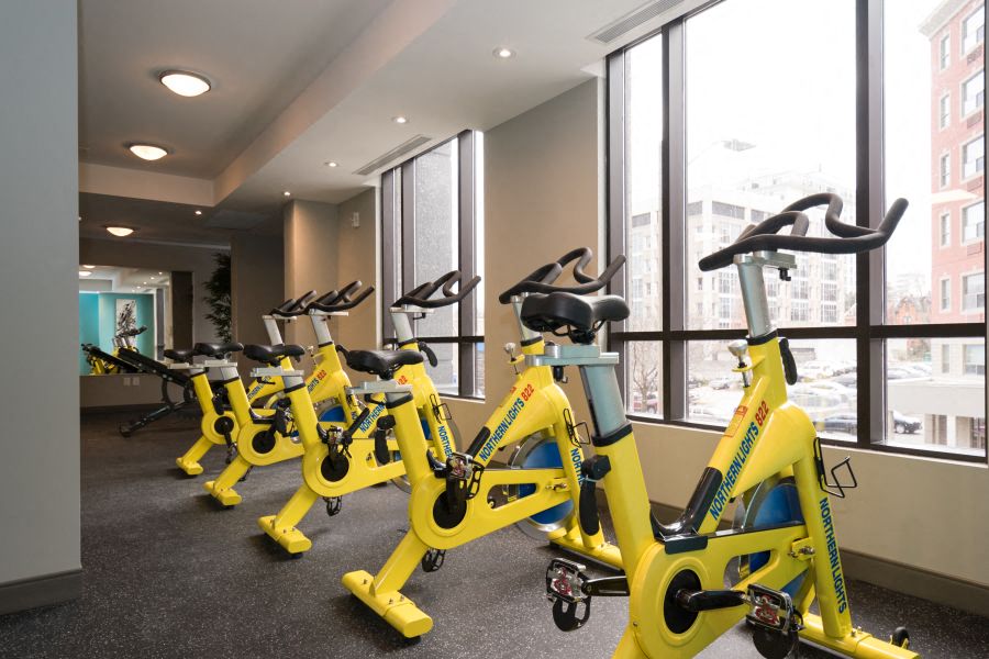 a group of yellow exercise bikes in a room