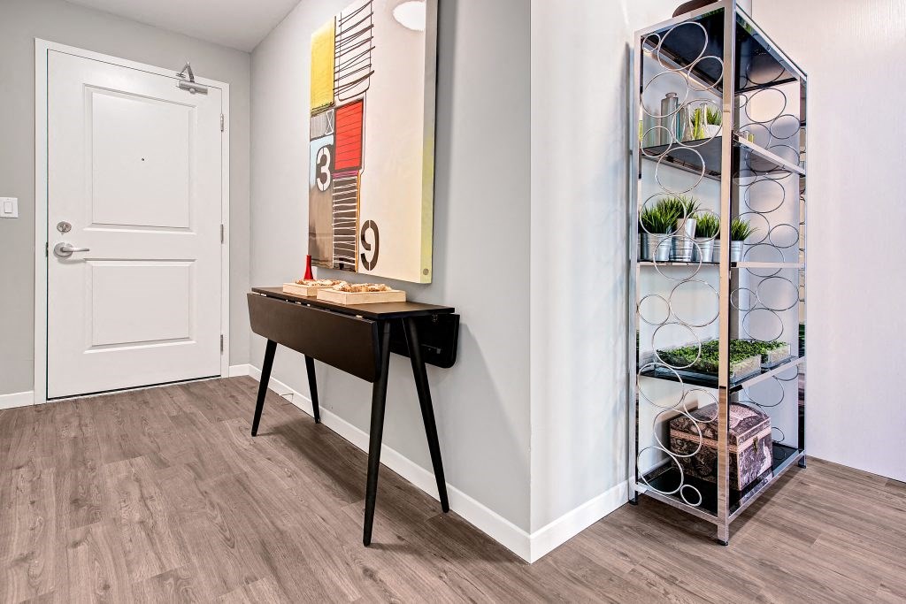 a small desk in a room with a shelf and a door