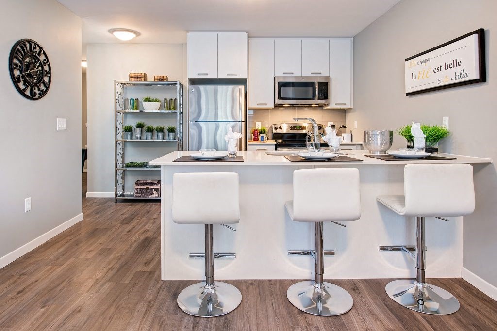a kitchen with a bar and a refrigerator