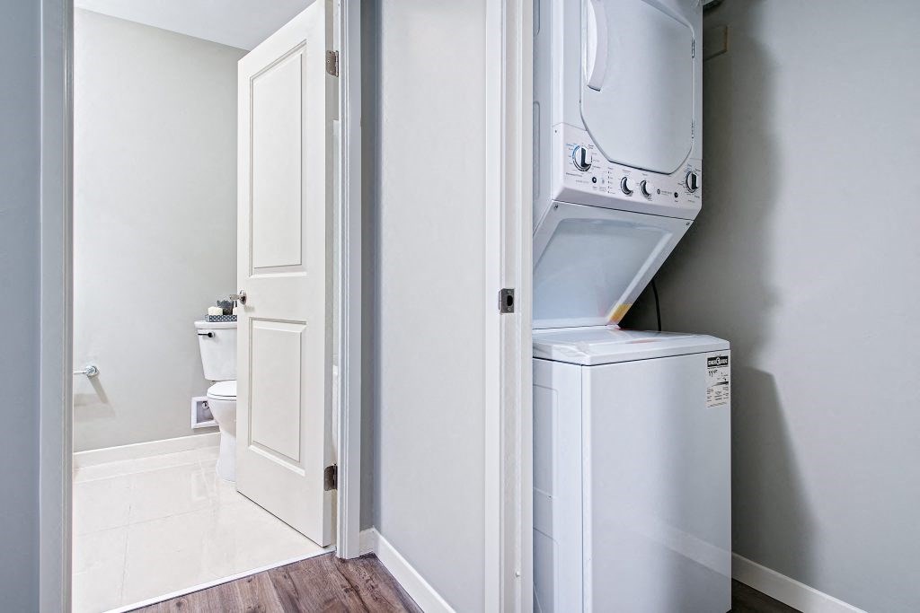a laundry room with a washer and dryer and a door to a bathroom