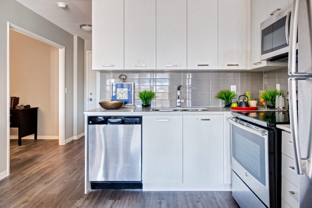 a kitchen with white cabinets and a dishwasher
