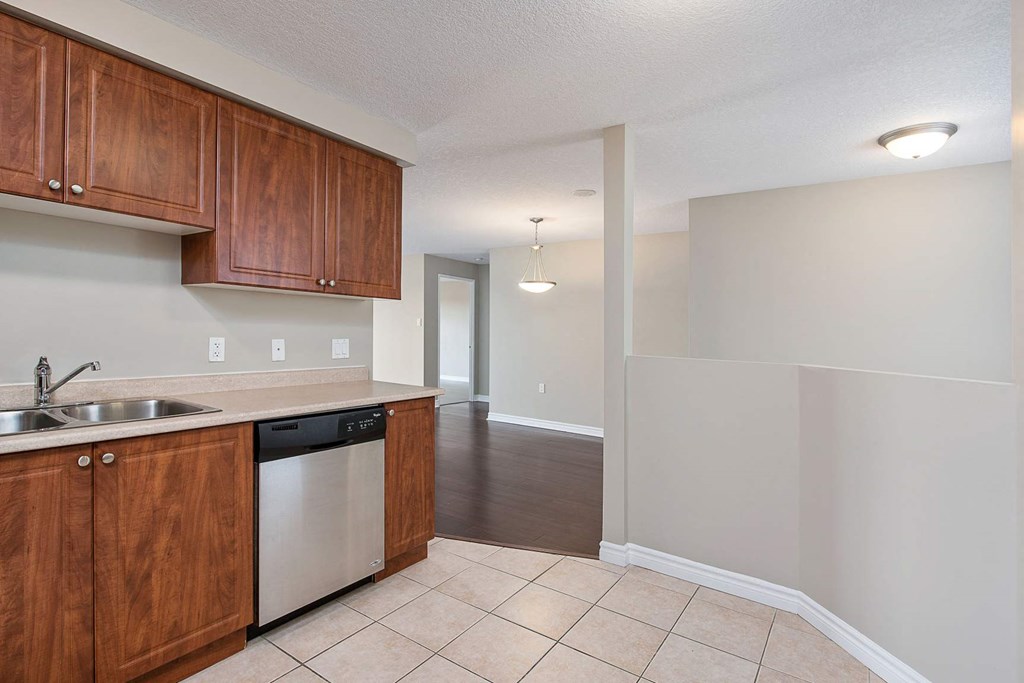 a kitchen with wooden cabinets and a white dishwasher