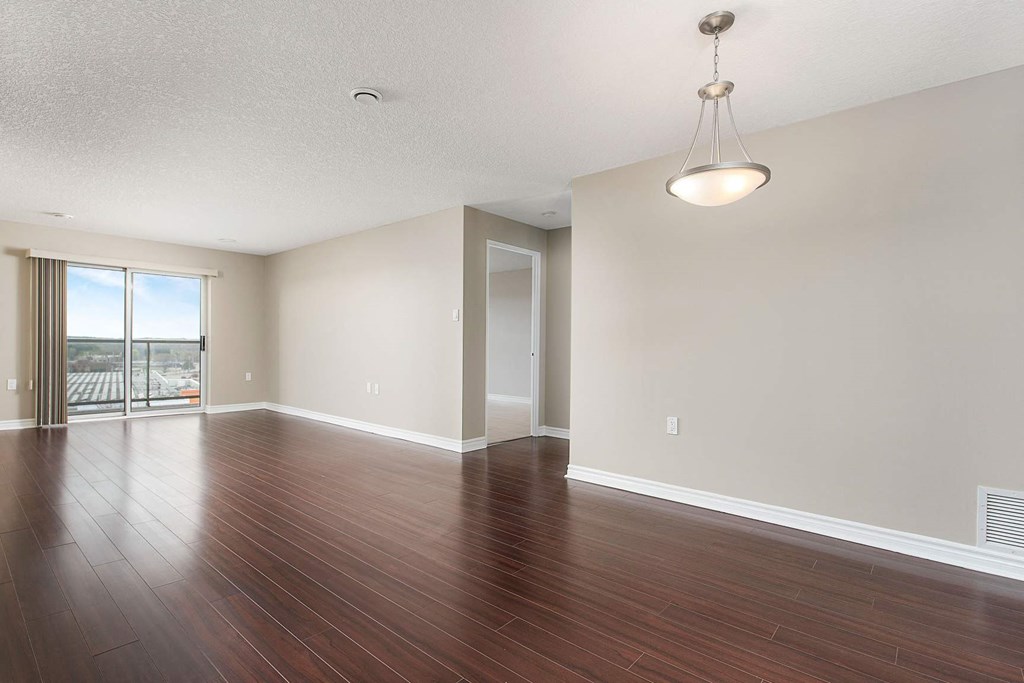 an empty living room with hard wood floors and a sliding glass door