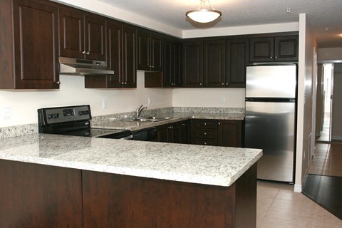 a kitchen with granite counter tops and a stainless steel refrigerator