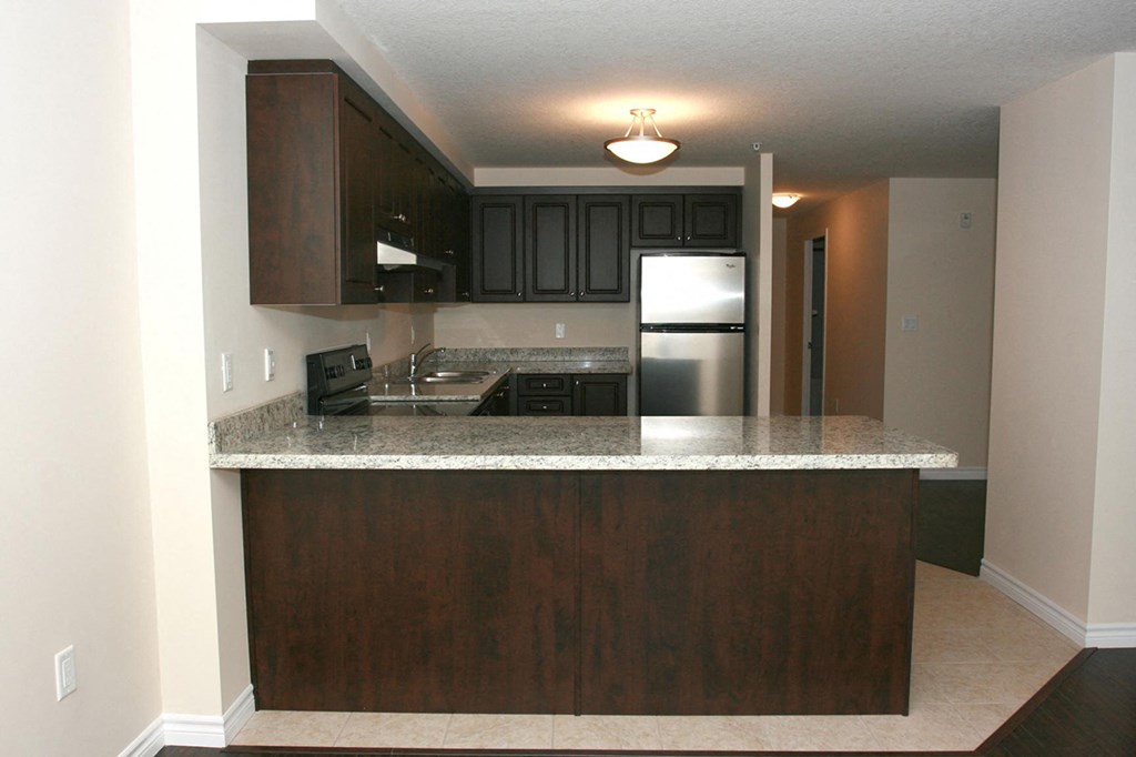 a kitchen with a granite counter top and a refrigerator