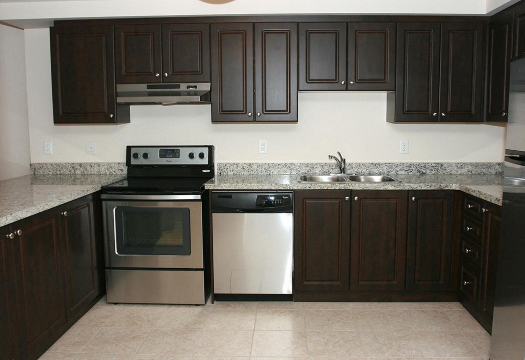 a kitchen with black cabinets and stainless steel appliances