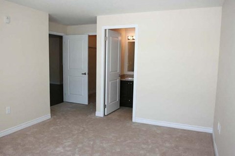 an empty living room with a door open to a bathroom