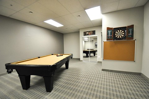 a games room with a pool table and a dart board