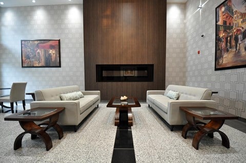 a living room with couches and tables in front of a fireplace