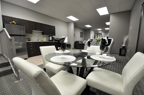 a dining room with white chairs and a glass table