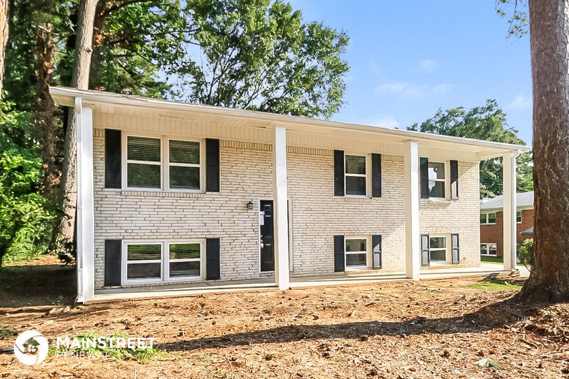 a white brick house with trees in front of it