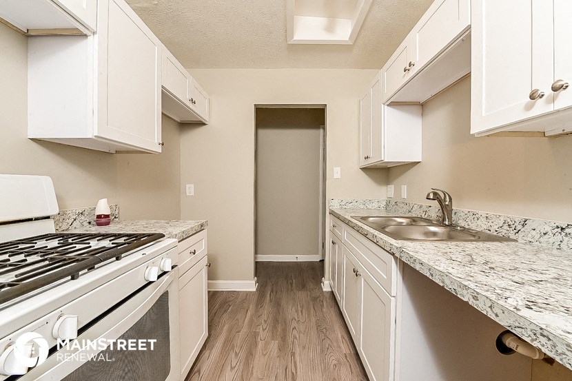 a kitchen with white cabinets and a stove and sink