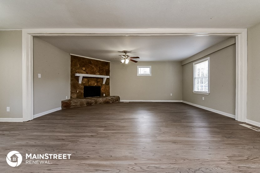 a living room with a fireplace and a ceiling fan