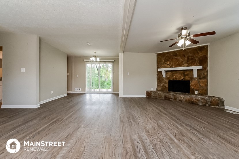 a living room with a fireplace and a ceiling fan