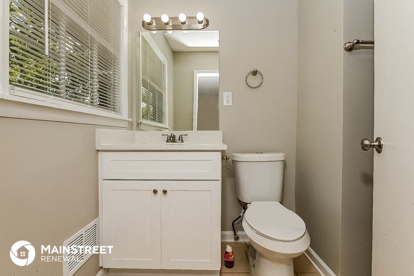 a bathroom with a toilet and a sink and a mirror