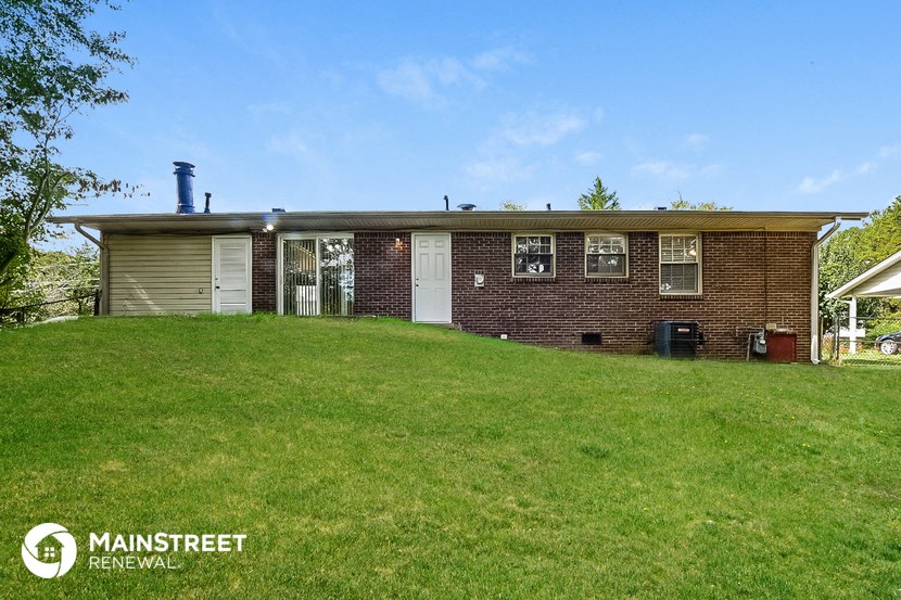 a brick house with a green lawn in front of it