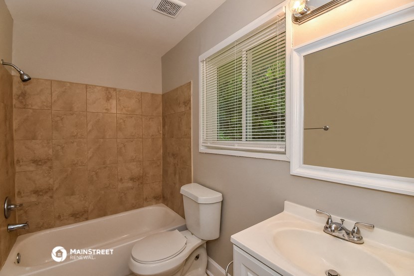 a bathroom with a toilet sink and a tub and a mirror