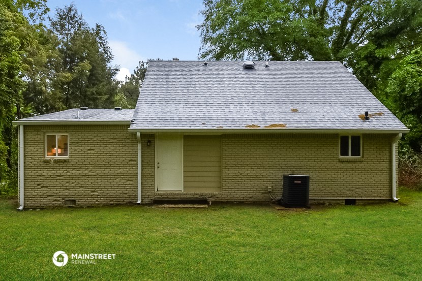 a view of the back of a house with a gray roof