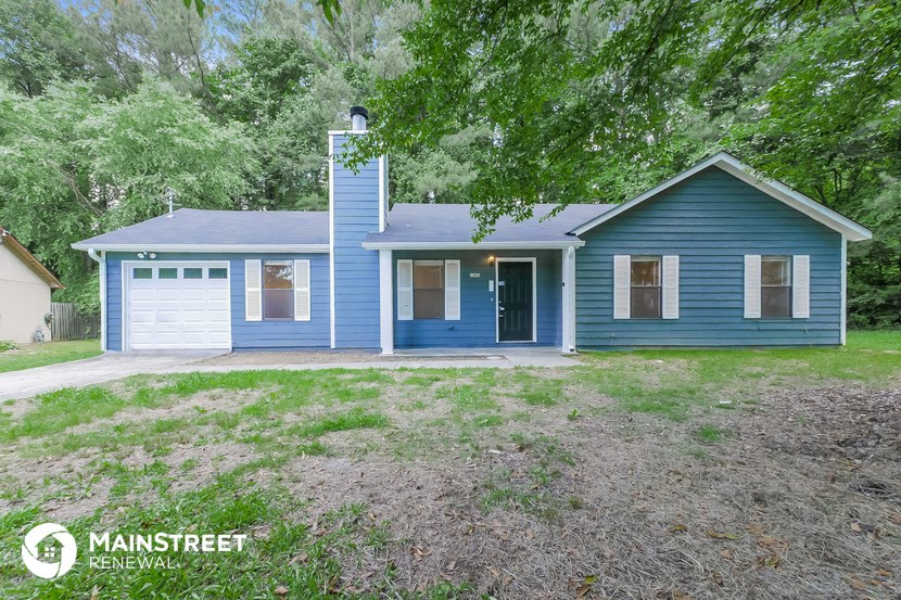 a blue house with a yard and a garage
