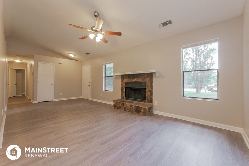 the living room with fireplace and ceiling fan