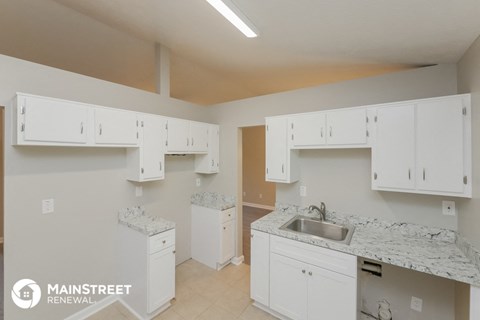 a kitchen with white cabinets and a sink and white counter tops