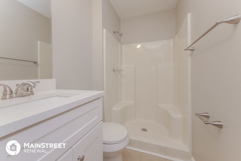 a bathroom with a shower and a sink and a toilet