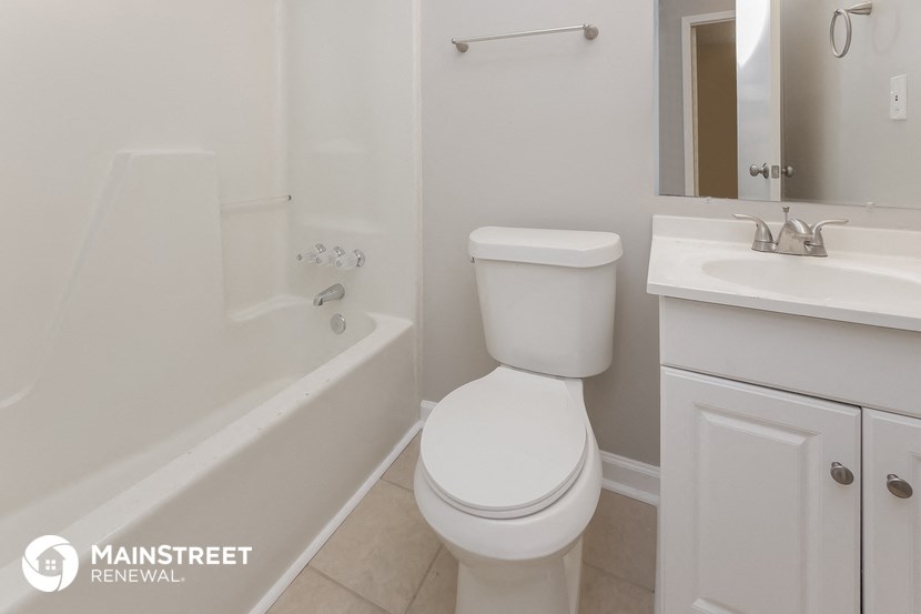 a bathroom with a toilet and a tub and a sink