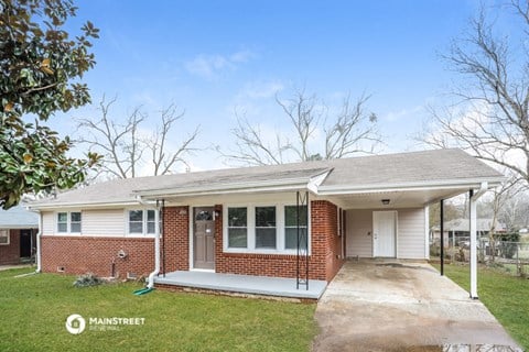 the front of a brick house with a covered porch