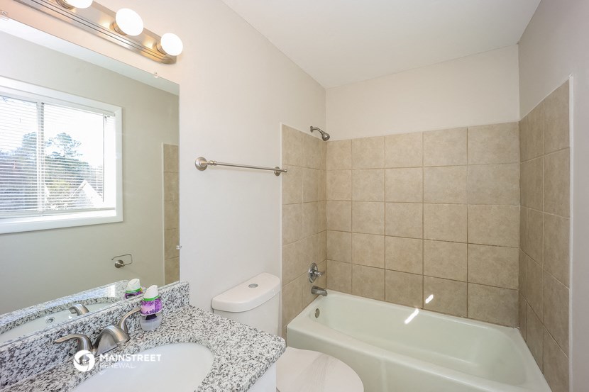 a bathroom with a tub and a sink and a toilet