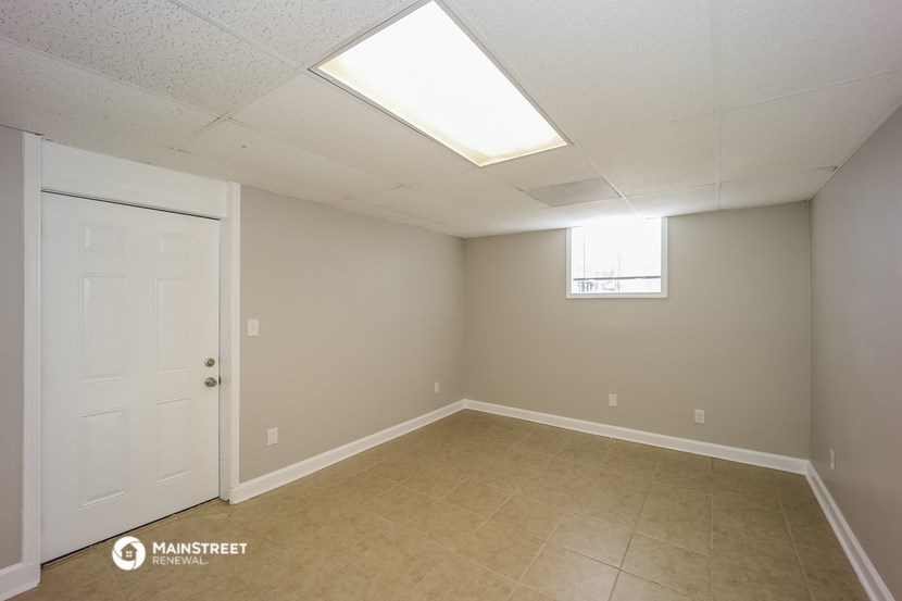 an empty room with a white door and a window