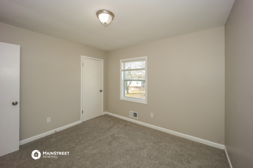 an empty room with carpet and a window