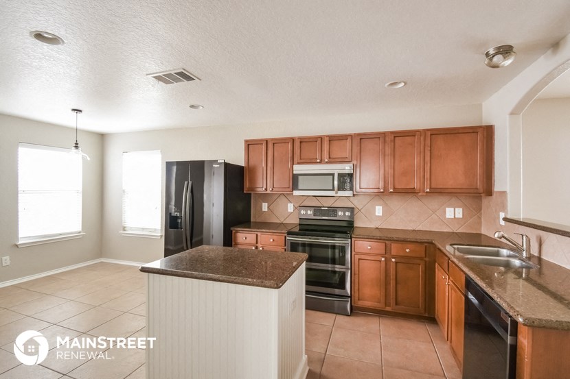 a kitchen with wooden cabinets and black appliances and granite counter tops