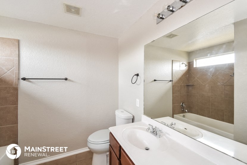 a bathroom with a sink toilet and tub and a mirror
