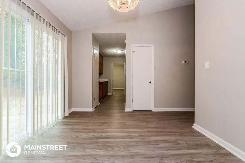 a hallway with a large window and a white door