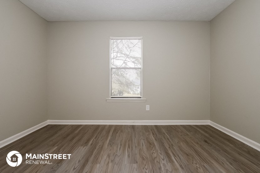 the interior of an empty room with wooden floors and a window