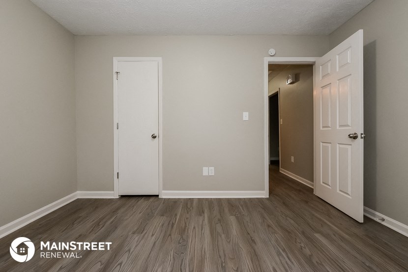 the spacious living room with a hallway to the bedroom