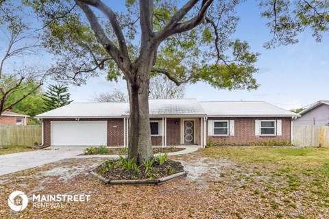 a home with a large tree in front of it