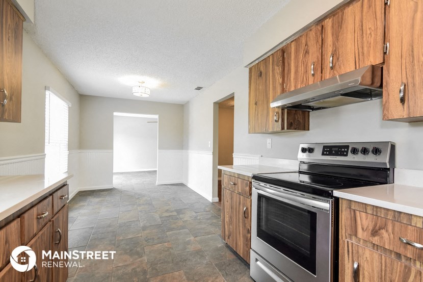 an empty kitchen with wood cabinets and stainless steel appliances