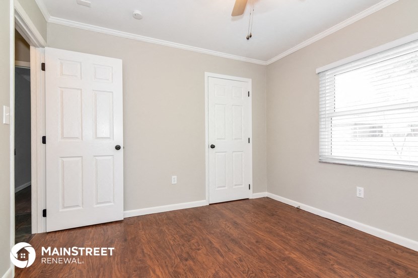 the living room of a home with a wood floor and two doors