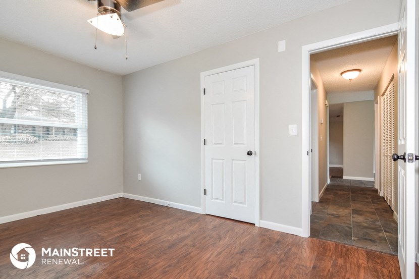 the living room and hallway of an empty house with a white door