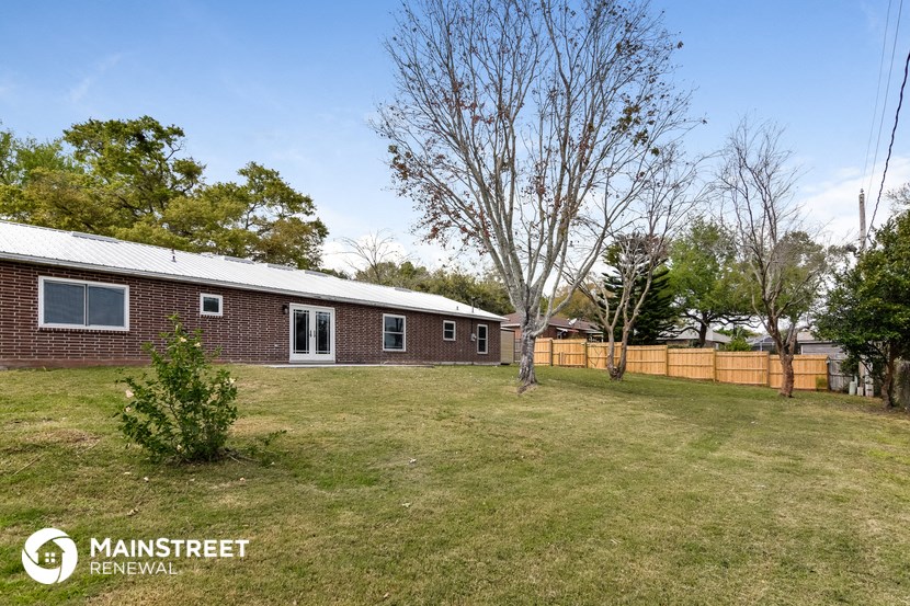 a brick house with a yard and a wooden fence