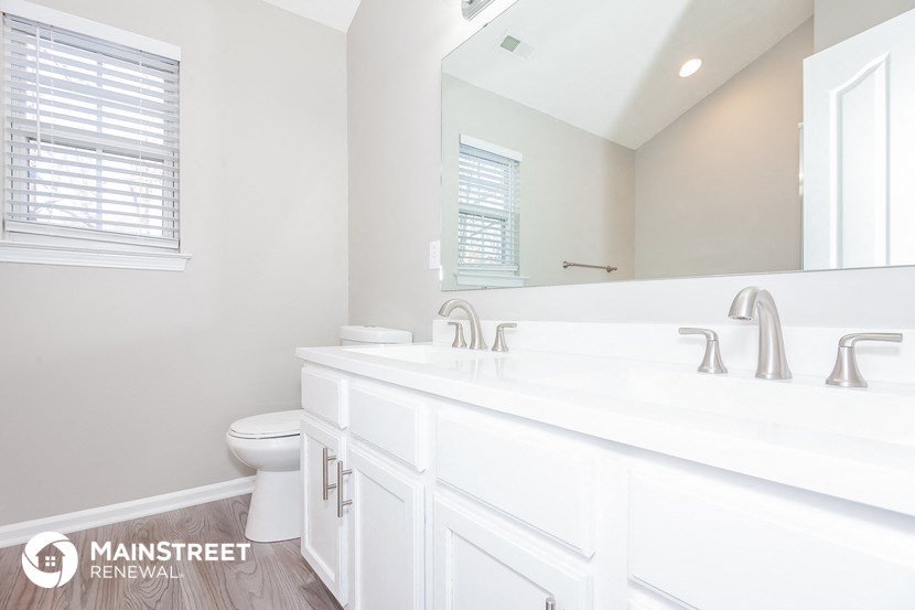 a white bathroom with a large mirror and two sinks